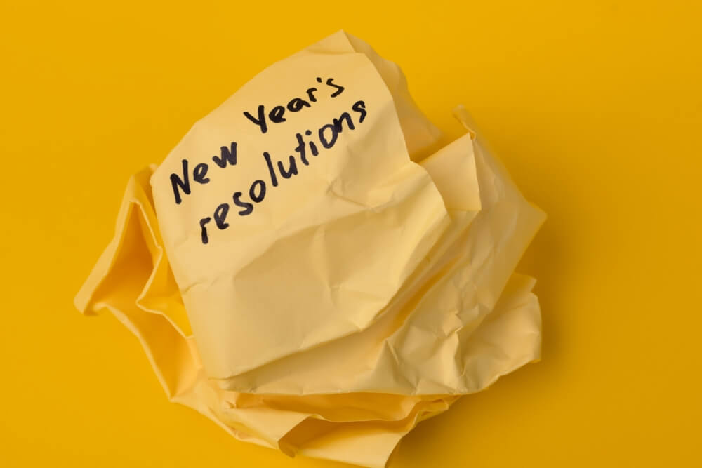 crumpled up yellow paper of new year’s resolutions