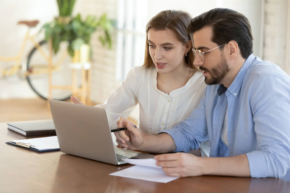 male coach discussing something with female coachee over laptop