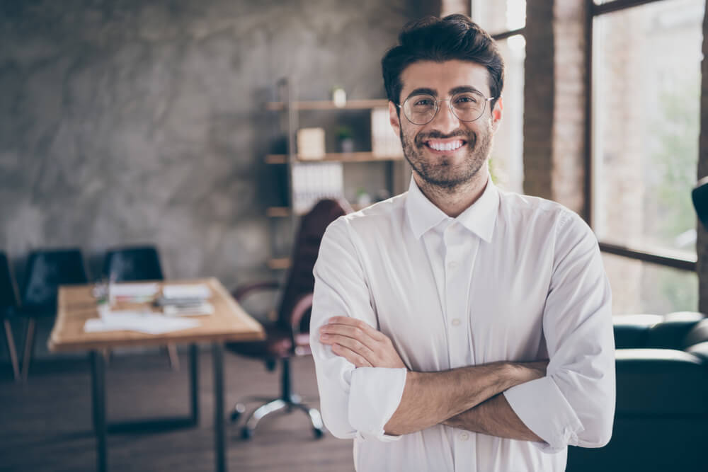 smiling young male coach or mentor with office background