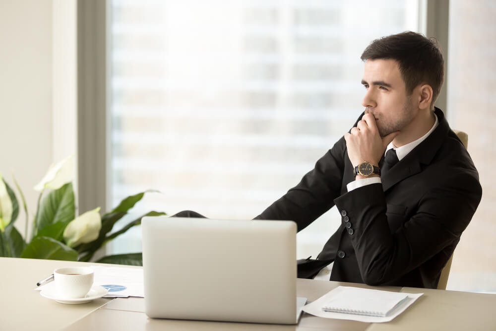 young male manager deep in thought