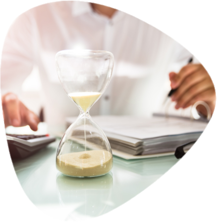 businessman calculating bills behind an hour glass