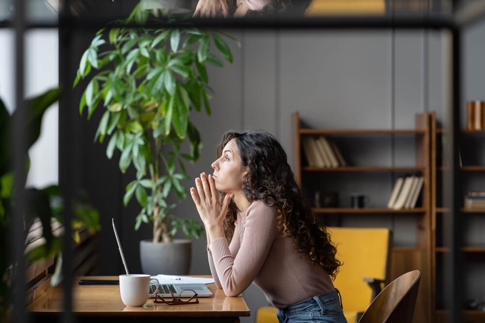 female employee in thought sitting in the office