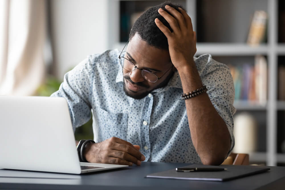 upset male employee looking at laptop