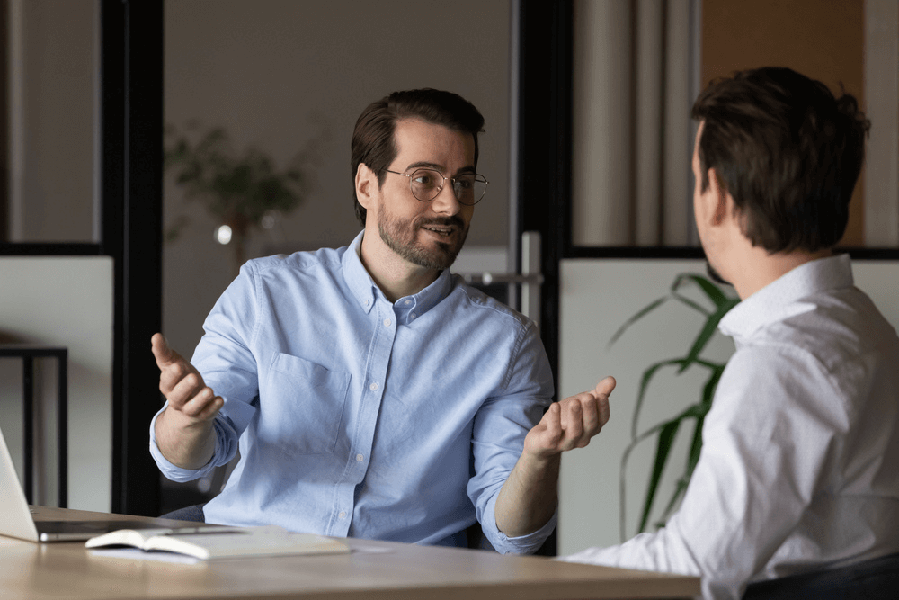 male career coach talking to male coachee in office