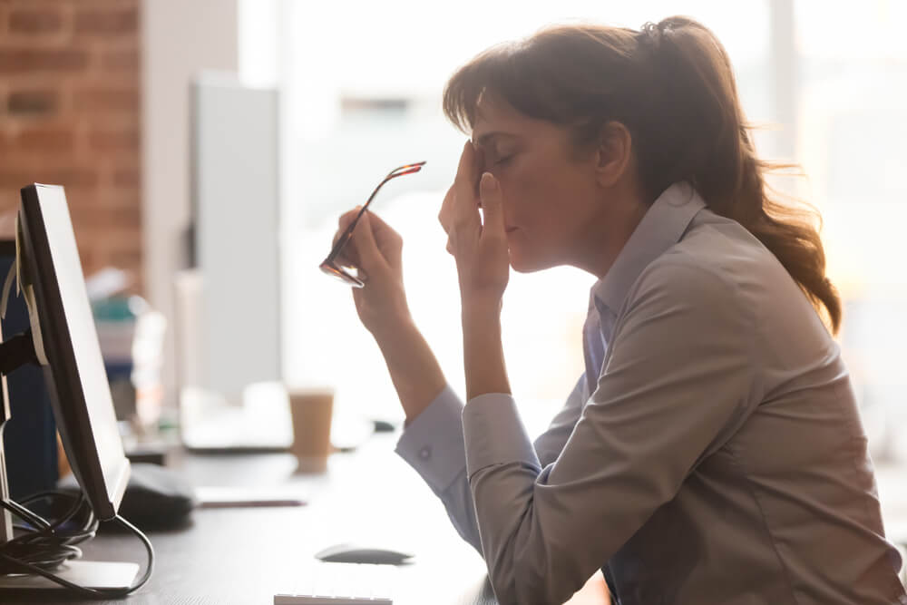 exhausted female worker sitting on work desk