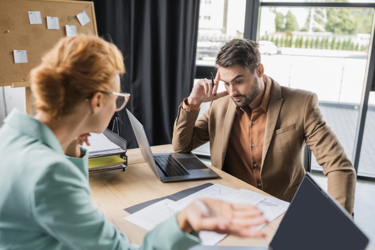 Discouraged employee talking to a disappointed manager