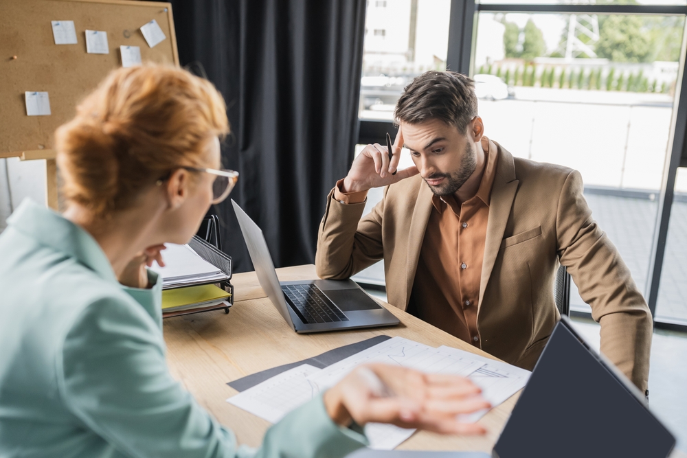 Discouraged employee talking to a disappointed manager
